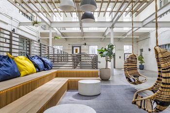 A living room with two hammock chairs and a wooden bench